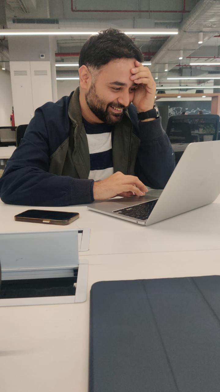 Abhishek laughing at his laptop